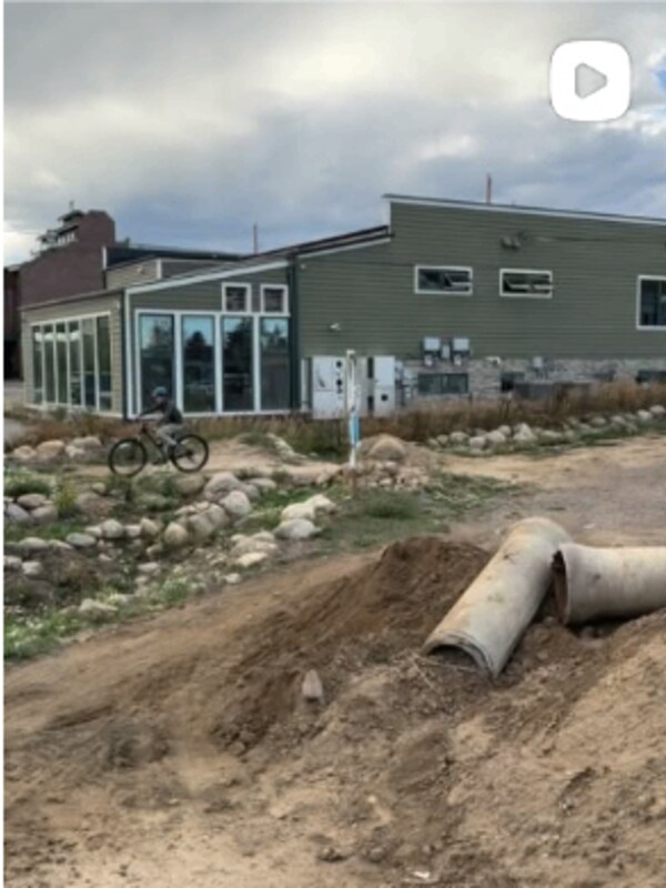 Dirt drop at High Performance Earthworks shop. Culvert set, lips shaped — trail building progress.
